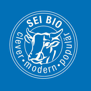 Das Bild zeigt ein Logo mit einer Kuh und dem Schriftzug „SEI BIO – clever, modern, populär“.