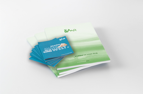 Auf dem Bild sind ein Produktkatalog und mehrere Informationsblätter mit dem Thema Biokäse zu sehen.