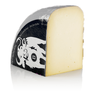 Auf dem Bild ist ein Stück Käse zu sehen, das in einer Verpackung mit einem schwarzen Etikett dargestellt ist.