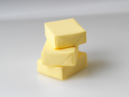 Auf dem Bild sind drei Stücke Butter übereinander gestapelt zu sehen.