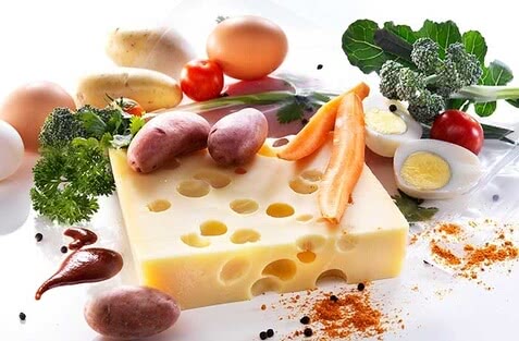 Auf dem Bild sind verschiedene Lebensmittel wie Käse, Eier, Gemüse und Gewürze zu sehen.