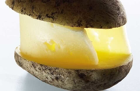 Auf dem Bild ist eine Kartoffel zu sehen, die so aussieht, als ob sie mit Butter gefüllt wäre.