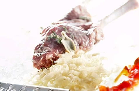 Auf dem Bild ist ein Stück rohes Fleisch zusammen mit gehacktem Gemüse zu sehen.