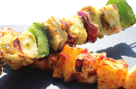 Auf dem Bild ist ein bunter Spieß mit gegrilltem Gemüse und Fleisch zu sehen.