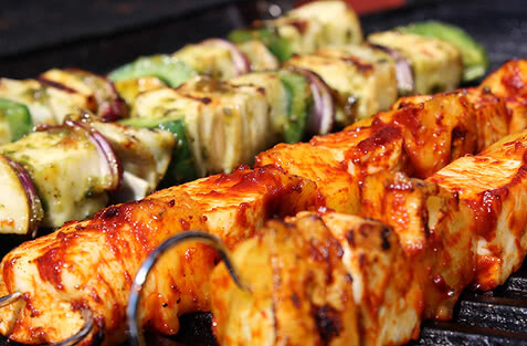 Auf dem Bild sind leckere gegrillte Spieße mit Fleisch und Gemüse zu sehen.