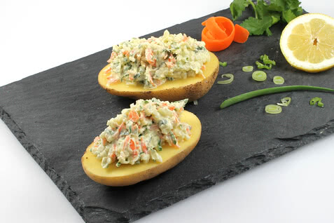 Auf dem Bild sind halbierte Kartoffeln zu sehen, die mit einer bunten, cremigen Füllung aus Gemüse garniert sind.